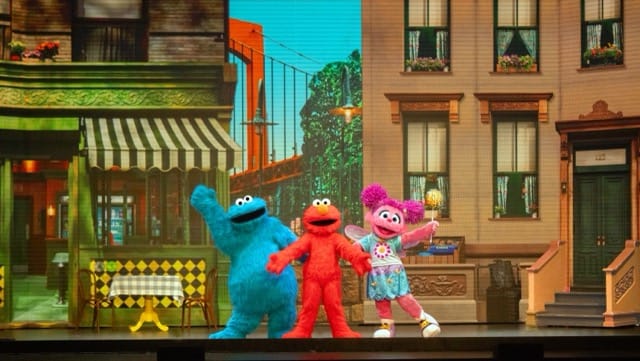 Elmo, Cookie Monster and Abby Cadabby stand together